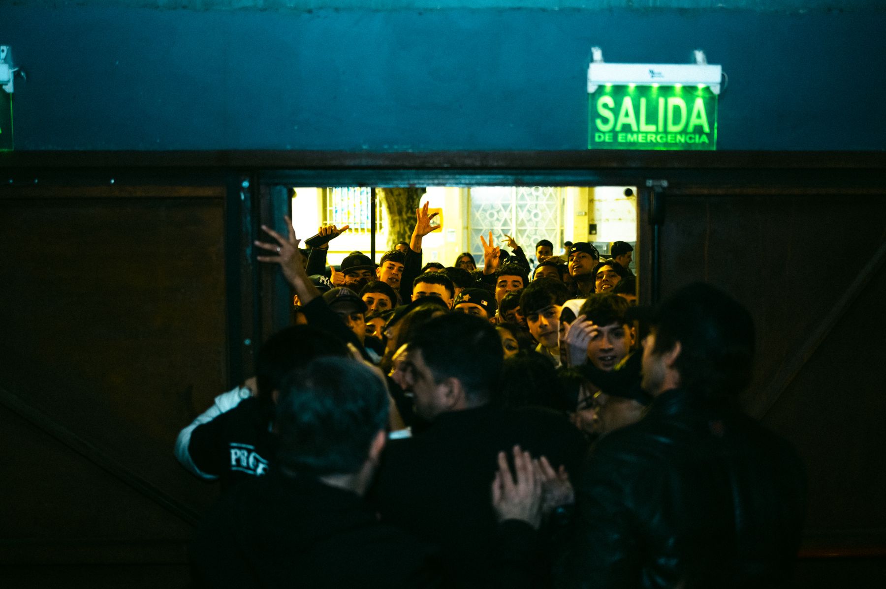 Fans en la puerta de salida estirando las manos