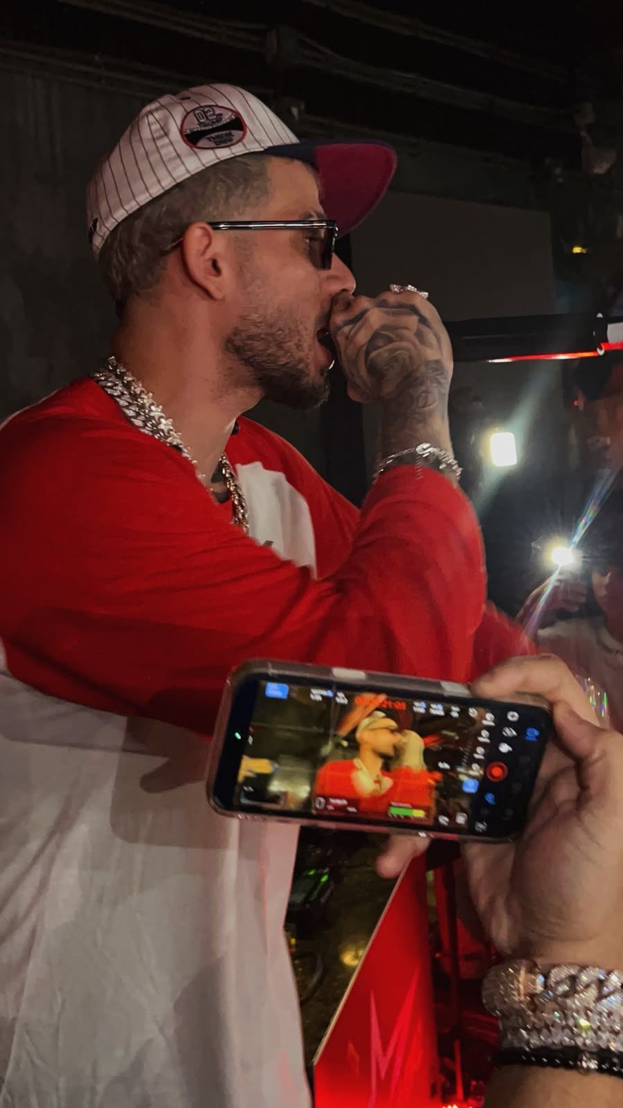 Dei V de rojo entre los fans, filmado con un celular